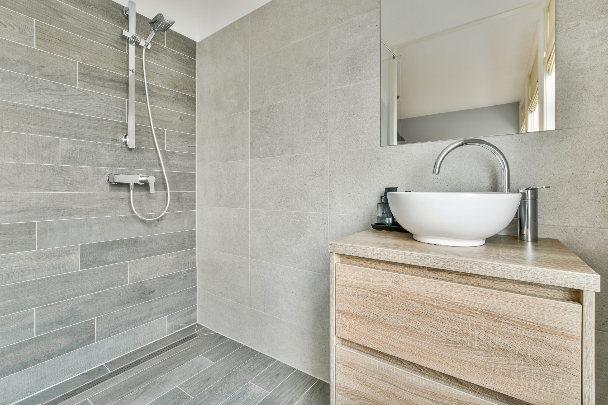 Open shower in gray tiled room