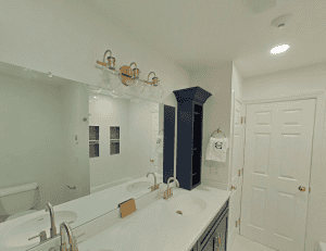 Elegant bathroom with double sink, large mirror, and stylish lighting fixtures.