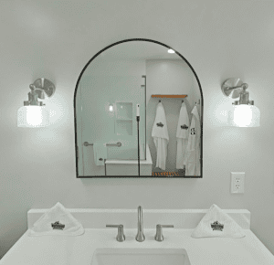 Bathroom mirror with lighting and towels.