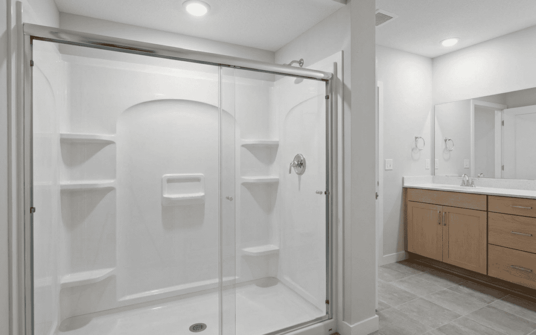 Modern white shower with glass doors in a clean bathroom setting.
