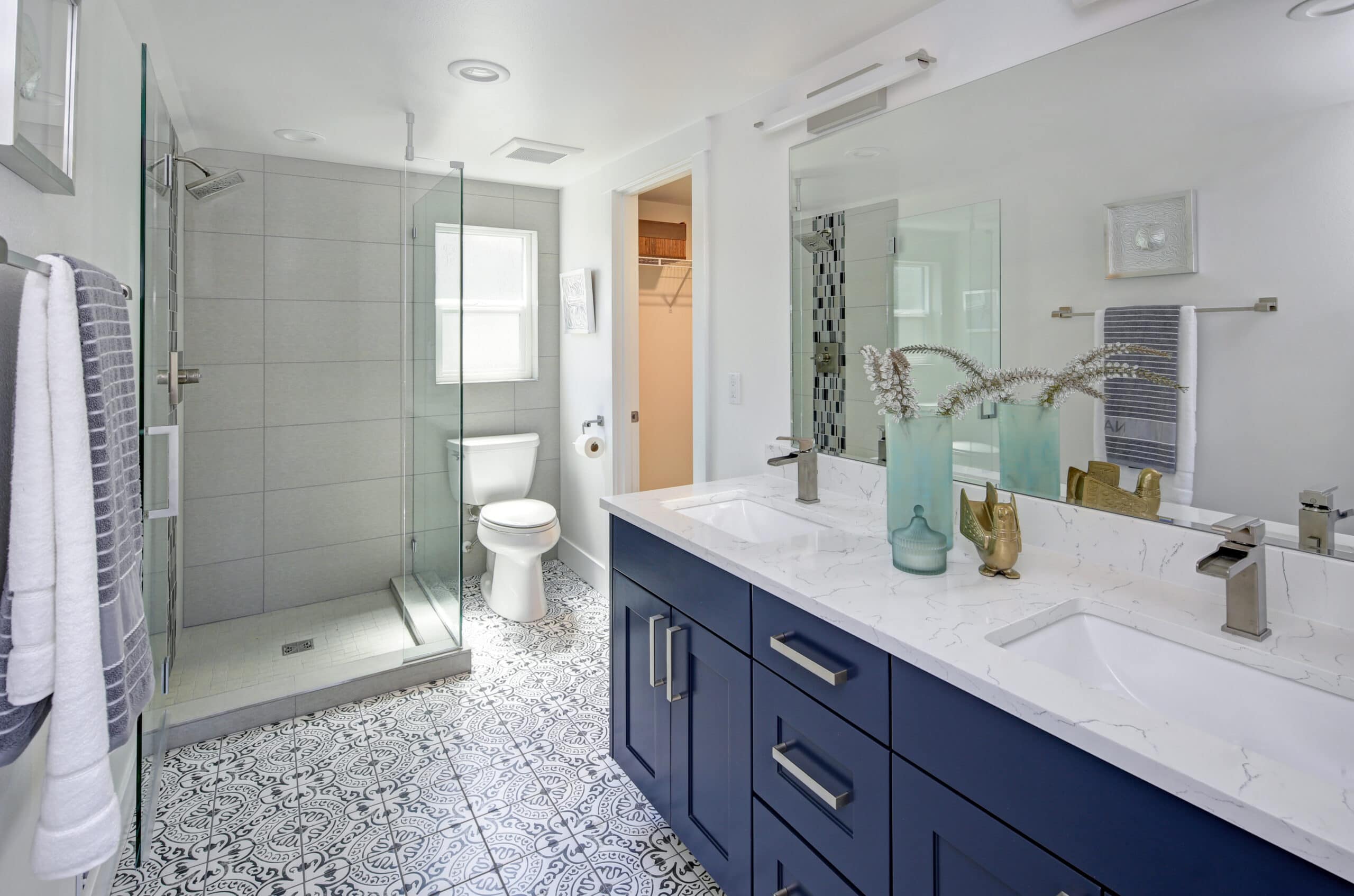Modern bathroom with walk-in shower, double vanity, and stylish decor from Blue Mountain Bathrooms.